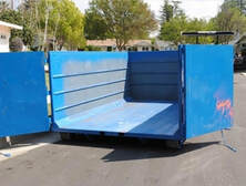 A open blue dumpster.