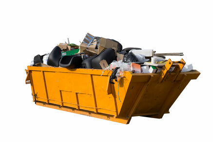 Yellow dumpster rental with garbage inside.