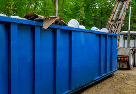 Blue dumpster in a residential street.